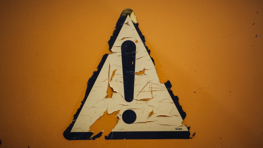 a triangle shaped sign on a yellow wall